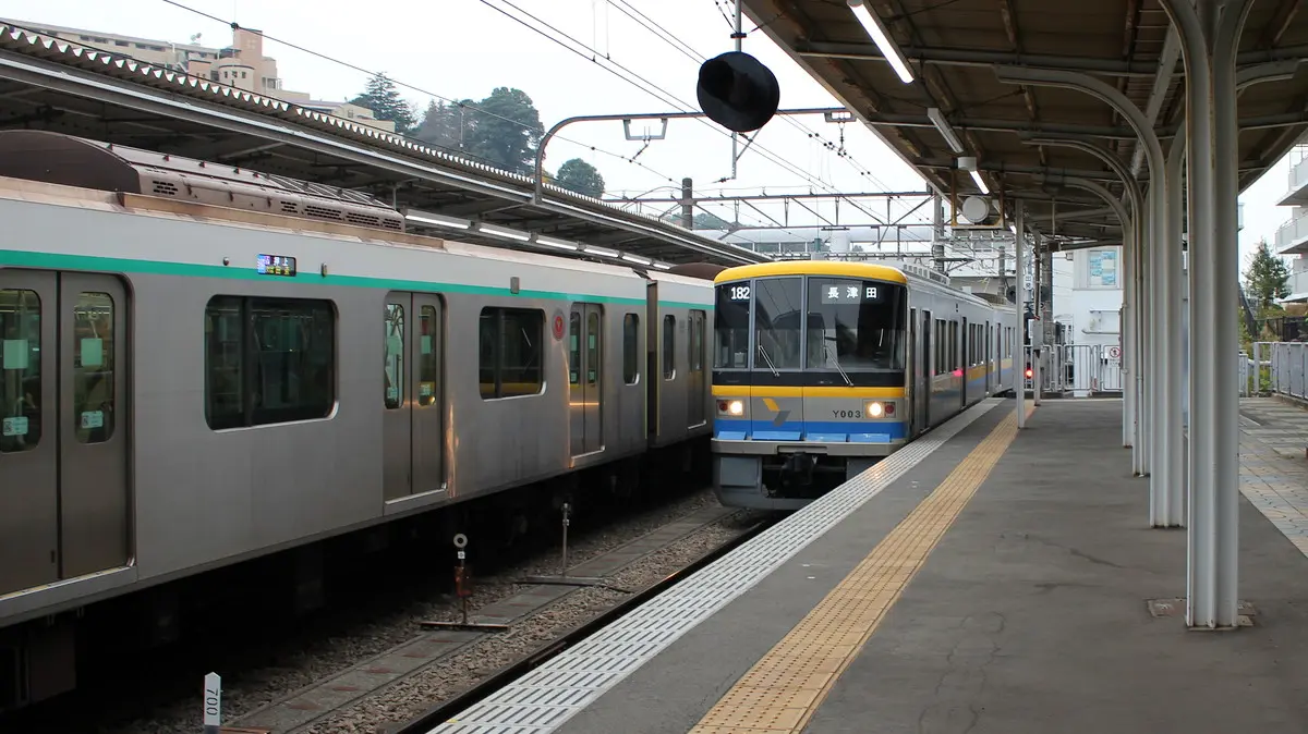 Tokyu Kodomonokuni Line Y000 series train alongside the Denentoshi Line at Nagatsuta Station